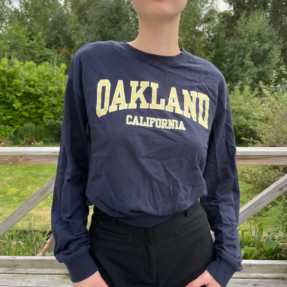 Mörkblå collegetröja från HM. På tröjan står det ”Oakland, California”. Hoodies.