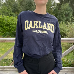 Mörkblå collegetröja - Mörkblå collegetröja från HM. På tröjan står det ”Oakland, California”