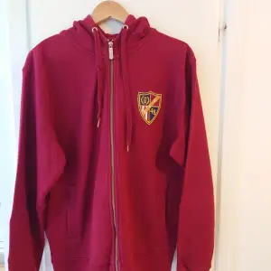 En röd hoodie från märket Gant i storlek XL. Knappt använd och i bra skick, men har legat i garderoben i ett par år. Inga märken eller skador. 