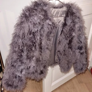 Strutsjacka - Lila jacka i äkta strutsfjädrar använd enstaka gånger. Okänt märke. Passar väldigt bra till fest!