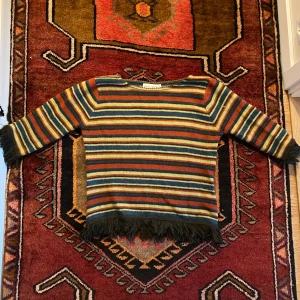 Multifärgad stickad tröja med fransar - Multifärgad stickad tröja med trekvarts ärmar. I storlek S(skickar mått vid intresse) Aldrig använd och i mycket bra skick!🖤