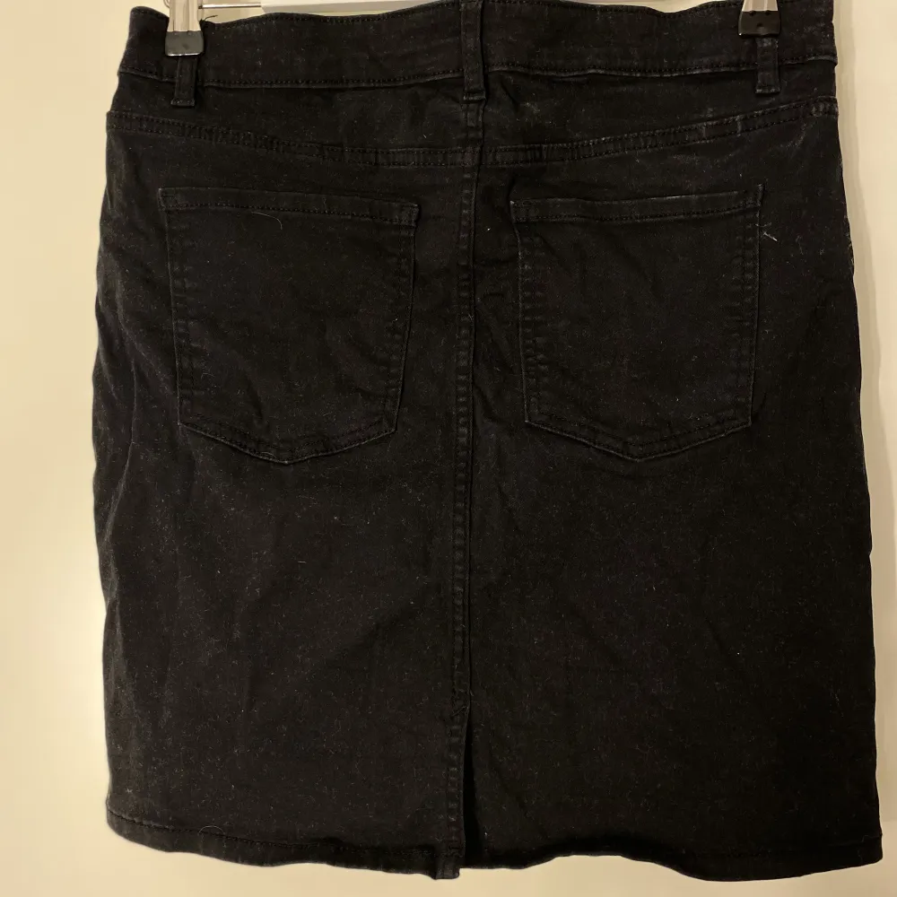 En svart stretchig jeanskjol från Cubus i storlek L.. Kjolar.