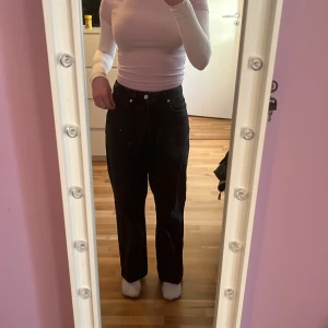 Svarta jeans - Ett par svarta jeans i modellen Regular Wide, Waist 28. Längden är 32 men de är uppsydda så de passar mig som är 162 cm. De har knappgylf. Märket är never denim och de köptes på Volvon för ett år sen ungefär. Mycket fint skick utan slitningar.  