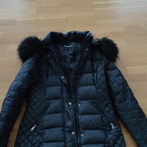 Snygg jacka i dun från ROCK AND BLUE - Snygg jacka i dun från ROCK AND BLUE. Har sparsamt använts i två vintrar och jackan är i väldigt god skick. Avtagbart luva i fuskpäls. Nypris för jackan 3499 kr.
