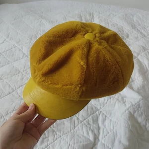 Senapsgul läderkeps  - Gul läderkeps med fejkläder och fuskpäsk. 