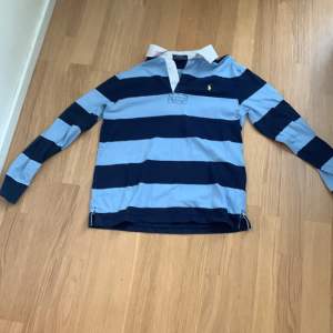 En randig polo rugby tröja med färgen blå