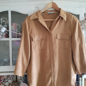 Vintage skjorta i mockaimitation  - Beige skjorta i mockaimitation, köpt second hand. I strl 42 och även jättesnygg som oversized!! 