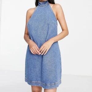 Topshop - mellanblå jeansklänning med halterneck - Sprillans ny klänning. Hann inte skicka tillbaka den så måste sälja den istället! Ordinarie pris 509kr men säljer den för 250kr