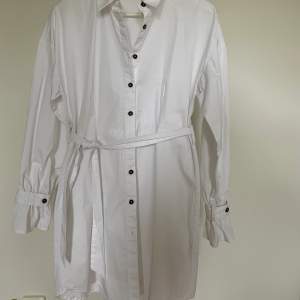 Vit skjortklänning med knytband i midjan ifrån Hoss kollektion med NAKD, använd 1 gång, fint skick. 