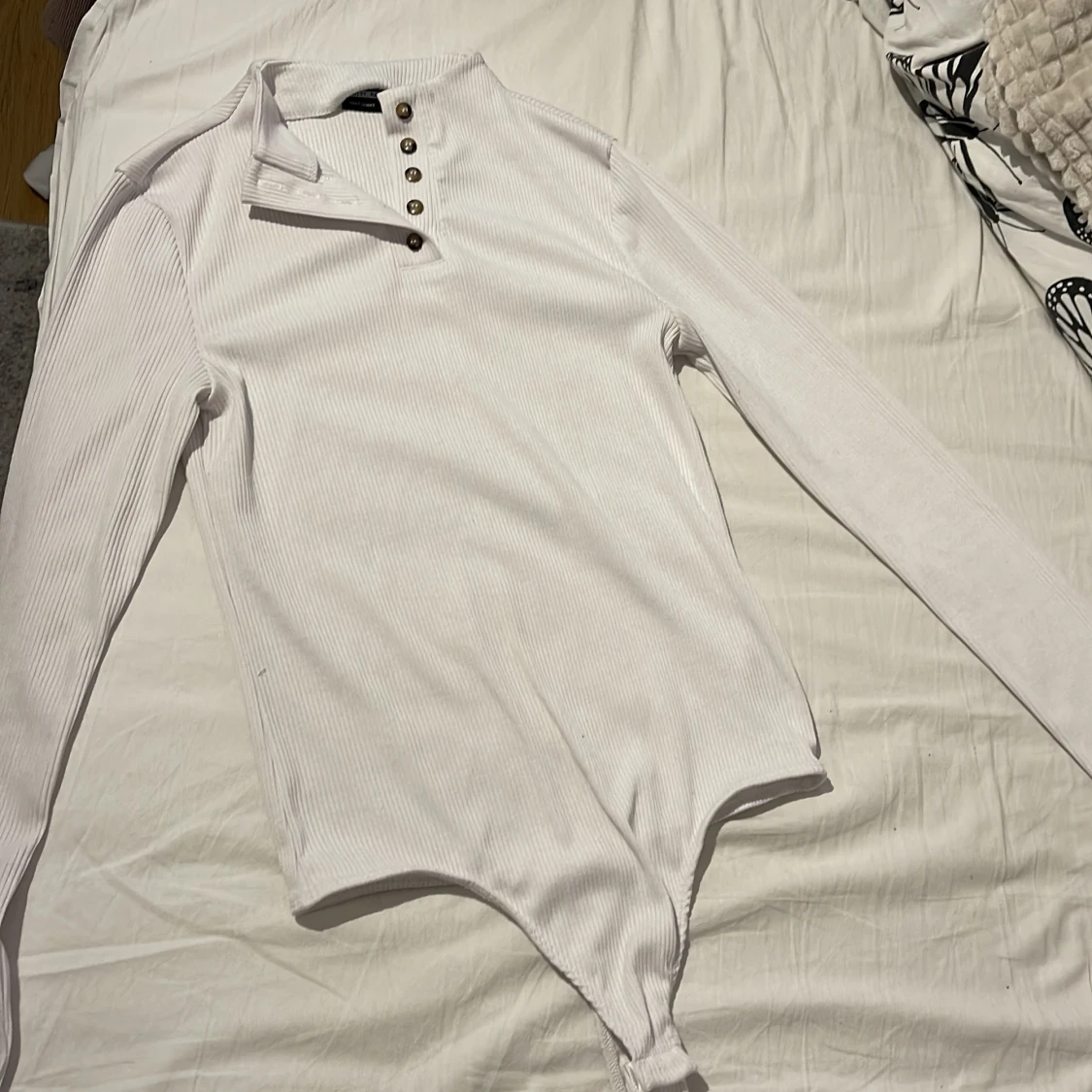 Vit långärmad body med knappar. - 91