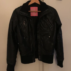 Skinnjacka svart S - Barnstolek men typ en S. Ganska sliten men det syns inte så mycket när man har den på sig. Har älskat denna jacka men köpt en ersättare nu 🥲 60kr
