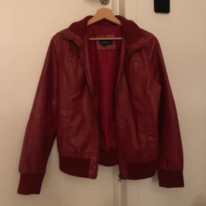 Skinnjacka röd - Röd skinnjacka i XL men skulle snarare säga att den är M-L. Den funkar på mig som vanligtvis är en S (157cm). Har inte kommit till användning så den är i bra skick 😜