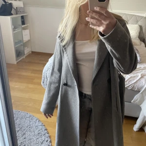 Lång grå kappa 🤍 - Jättefin lång ljusgrå kappa från Daniel Hechter. Både knapp och knytning🖤 mycket sparsamt använd och därför i väldigt fint skick! Hör av dig om du är intresserad eller har några funderingar🖤
