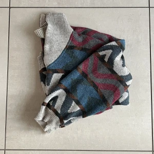 Stickad tröja med mönster  - Stickad tröja med mönster samt krage köpt second hand. Dova färger, mysig! Står varken märke eller storlek men skulle tippa på ca M. Sticks lite men inte så mycket, plus om man har t-shirt under så känns det ej. Bra skick!