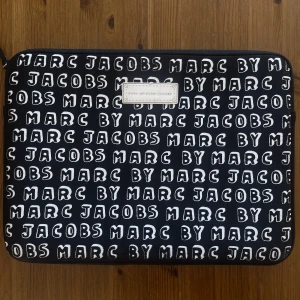 Marc Jacobs datorfodral - Rymligt laptopfodral från Marc Jacobs. Slitningar finns på vissa ställen av trycket. Måtten är 35*26 cm.