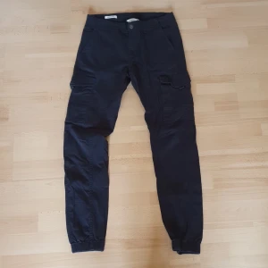 Svarta cargobyxor - Ett par svarta cargobyxor från JACK & JONES. Storlek: 30;34.