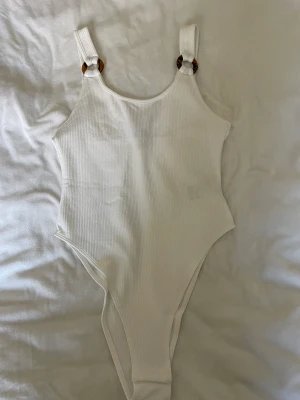 Body  - Vit body med träliknande detaljer. Superfin till jeans ✨ Använt ett fåtal gånger, i väldigt fint skick. Från H&M i XS. 