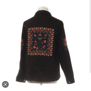 Jeansjacka med broderier - Säljer denna supercoola svarta jeansjackan med broderier från zara! Den är sparsamt använd (bara ett fåtal gånger) och är i bra skick. Kontakta för intresse!🥰KLICKA INTE PÅ KÖP NU KNAPPEN
