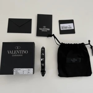 Valentino armband - Tja! Säljer nu ett fint och trendigt valentino armband i svart färg med silvriga nitar. Helt nytt, medföljer med extranitar, låda, dustbag etc. Finns även kvitto, garanterad äkthet. Lite oxidering på metallen i bild 3 (vanligt). Säljs för 1399 sek, STEAL!