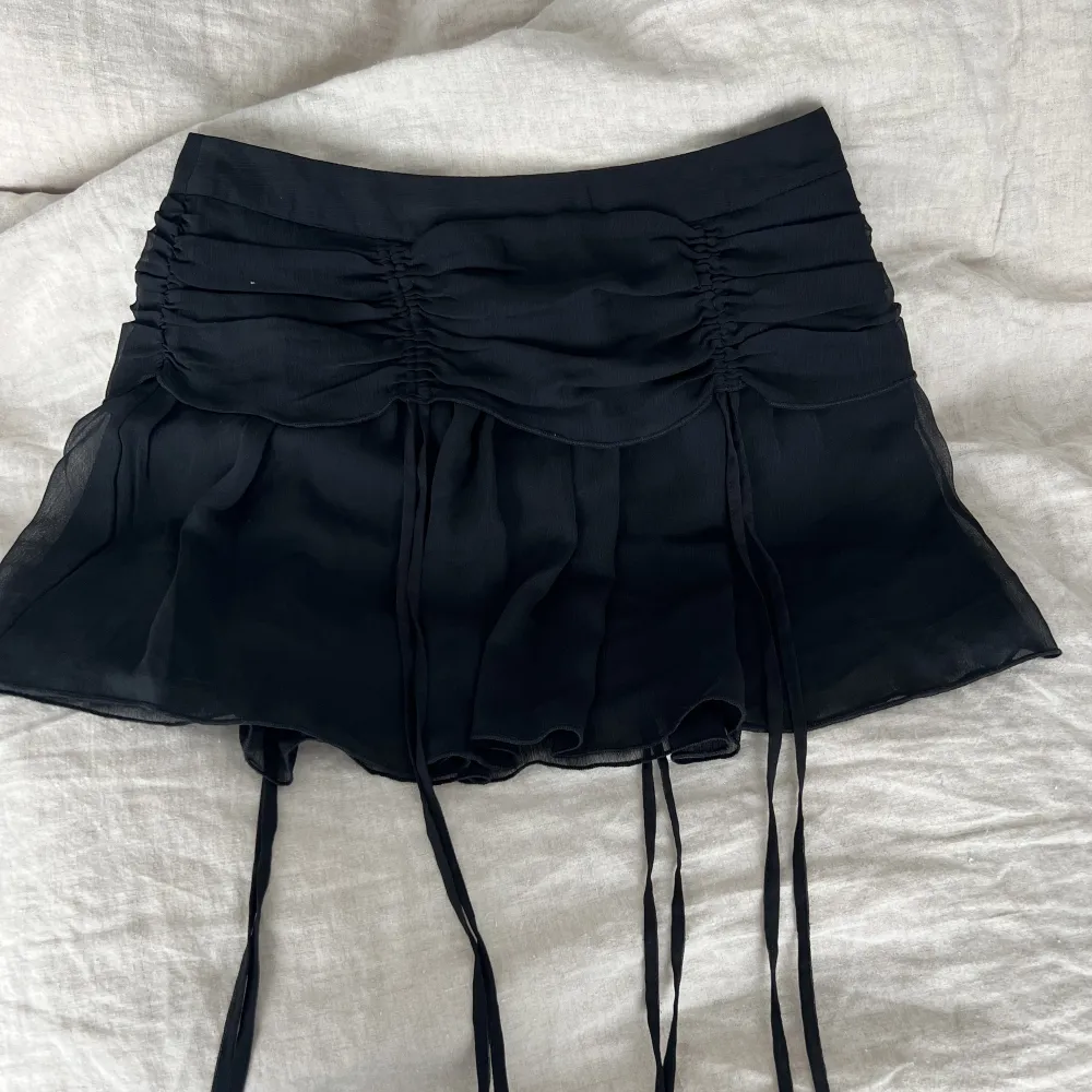 En svart kjol med snygga detaljer från nakd.   Storlek 36  Kan fraktas mot betalning annars möts upp i Stenungsund.       . Kjolar.