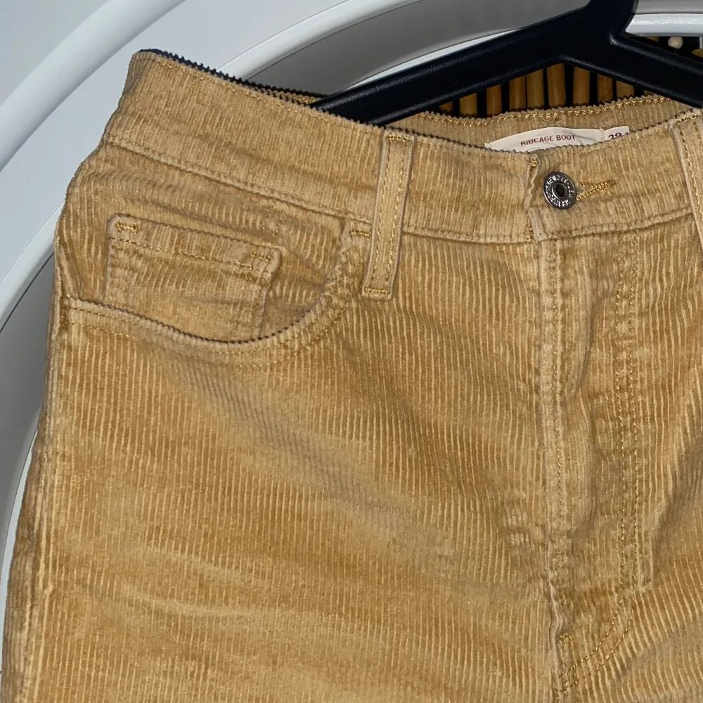 Beige/gula manchesterbyxor från Levis, modellen heter Ribcage. Storlek 28x33, fint skick då de är för stora för mig så inte blivit använda många gånger!. Jeans & Byxor.
