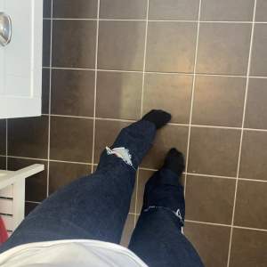 Mörkblåa bootcut jeans med hål. Mid waist. Storlek 34