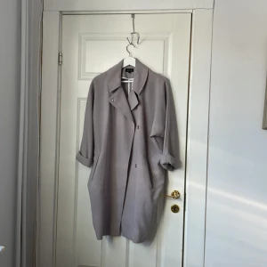 Grå kort kappa - Köptes från topshop för 1300kr. Sparsamt använd. Den är lite kortare i ärmarna. Tunn och passar för sen vår och sommar. Storlek 34 men passar mig som har 36.