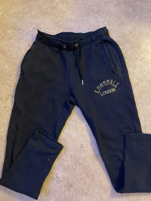 Lonsdale  - Säljer mina svarta mjukisbyxor i märker lonsdale . Sköna att träna i eller sköna hemma kläder. Super bra skick inte mycket använda. Finns en matchande hoodie. Pris kan diskuteras vid köp av både byxor och tröja . Hör av er vid frågor eller fler bilder