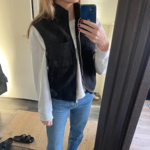 Teddy väst - Säljer en svart Teddy väst med en ficka vid vänstra bröstet. Silver kedja. Använd 2 gånger så helt som ny och i väldigt fint skick 