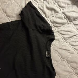 T-shirt - En svart t-short med lite volanger vid ärm och ner till u storlek XS🤗