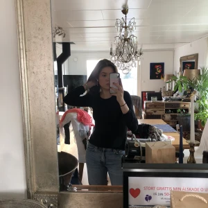 Svart långärmad  - Snygg svart långärmad tröja i super mjukt material, den har spetts över axlarna. Storlek Xs men passar även S