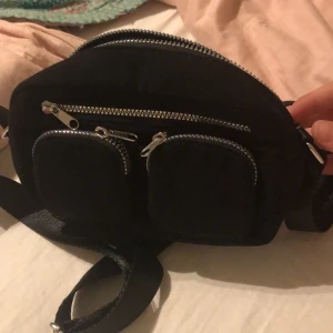 Väska - Fin väska från H&M som inte kommer till användning💕 bandet  kan man förlänga och korta om man vill och den har även fyra stycken fack💕 ett stort, en bred men smal och två små💕 ny pris var runt 200 och säljer för 100 och använt en gång💕💕