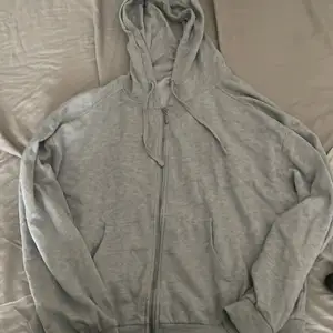 En vanlig grå zip up hoodie, i storlek xl men passar som S/M