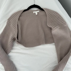 Stickad kofta - Beige/brun stickad kort ribbad kofta med lite längre ärmar🤎 helt i nyskick, aldrig använd. Frakten är satt som 66kr spårbart, men kan kolla om det finns billigare alternativ🤎