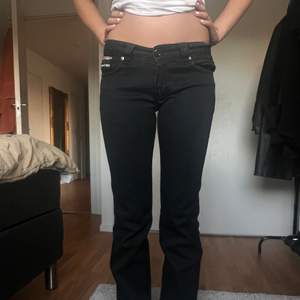 Jättesnygga, svarta, lågmidjade Burberry jeans med detaljer på bakfickan. Jeansen är raka i modellen och är i mycket bra skick. Midjemått rakt över: 39,5 cm. Innerbenslängd: 80 cm. Ben öppning: 20 cm