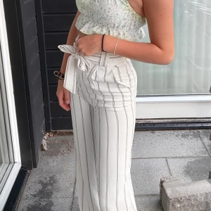 Randig kostymbyxor strl 32 - Snygga randiga kostymbyxor från H&M. Sitter för tajt på mig runt midjan men det förklarar storleken då dom är väldigt små i strl. Bandet går och ta bort runt midjan, använda ungefär 4 ggr och är i väldigt bra skick.💓 
