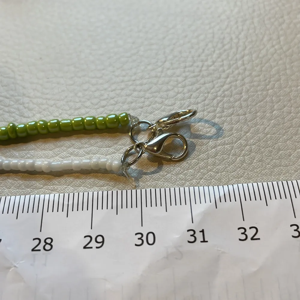 Två halsband, en av de gröna pärlorna, den andra av de mindre, vita pärlorna. De passar perfekt som delikata accessoarer . Accessoarer.