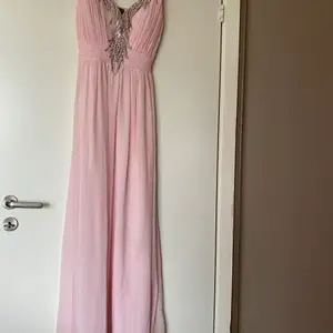 Långklänning i ljusrosa med strass detaljer. Använd 2 gånger. Perfekt till bröllop