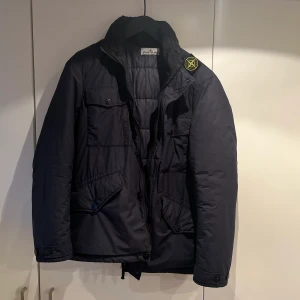 Stone Island vinterjacka - Säljer nu min Stone Island jacka i mörkblå, inköpt på NK Stockholm för 10000kr i Januari. Jackan är i toppskick och ser i princip som ny ut. Finns Luva som är ”inbyggd” i jackan och kan fällas ut vid behov. Storlek Medium. Tveka inte på att kontaka mig!