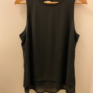 Svart blus  - Svart fin blus med två guldknappar från H&M    Stl. 40 men är som 38 Bra skick, använd fåtal gånger