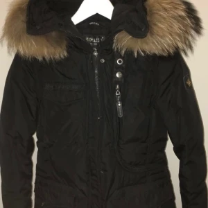 Vinterjacka strl 34 - Detta är en fin och skön vinterjacka från Hollies. Den är i väldigt bra skick. Jackan köptes för 5198 kr.   Storlek: 34/XS. Den sista bilden är samma jacka (bild från deras hemsida).