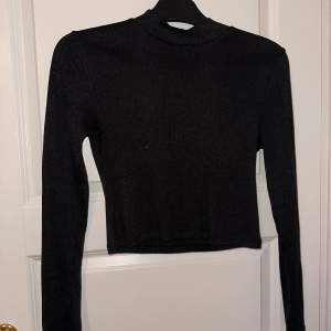 Svart cropad långärmad tröja men en liten polokrage i storlek S från H&M. Köpt för 149 kr
