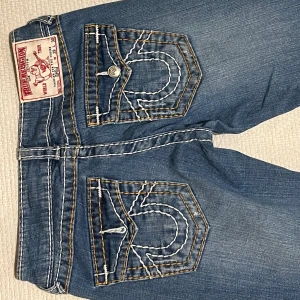 True Religion Jeans - Ett par riktigt snygga Trueys i nyskick! Aldrig använda då de är för små för mig, har inga defekter. Skriv för mer info, pris kan diskuteras! Storlek 29 men de är små i storlek  