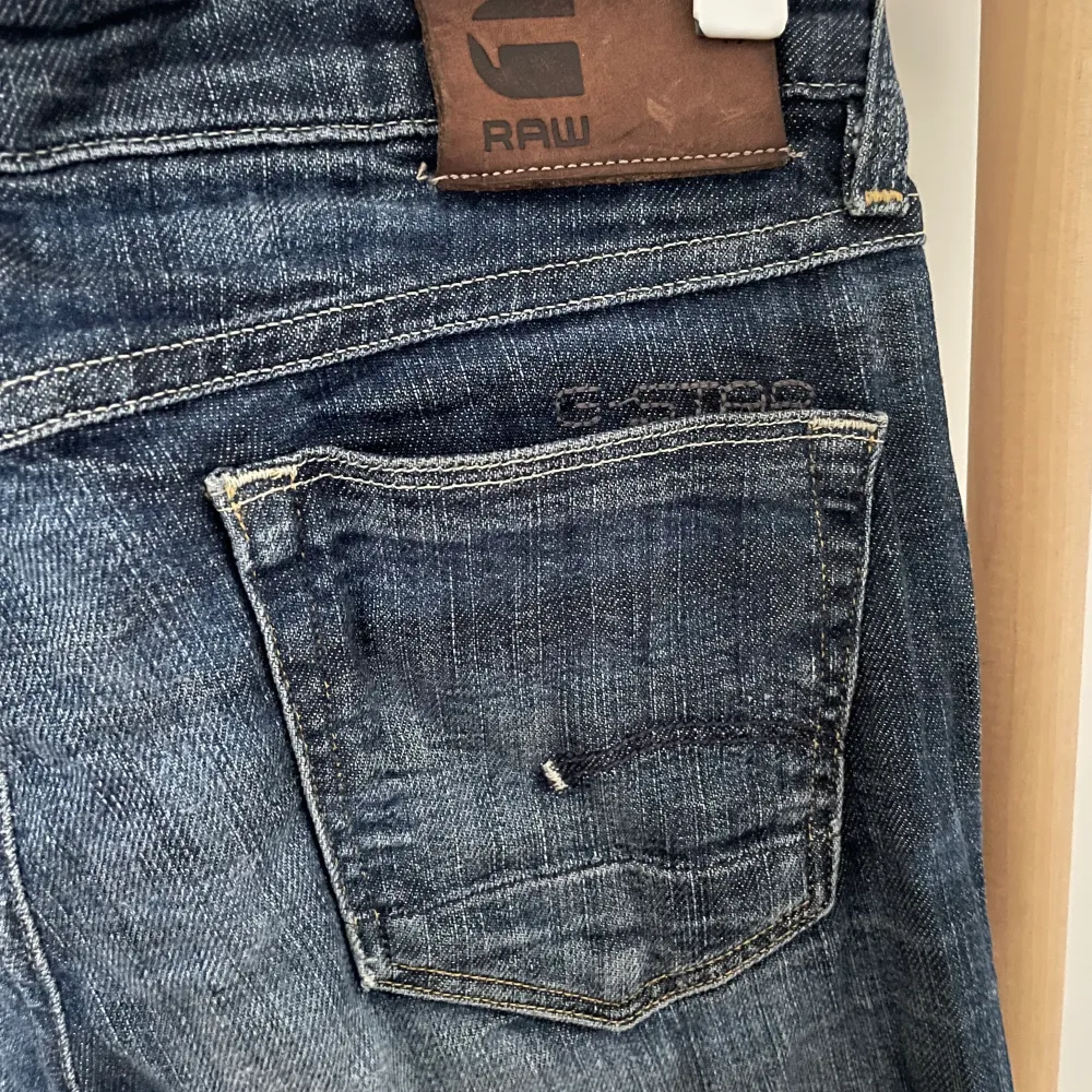 Mörkblåa jeans från G-STAR RAW med slitning på knät . Jeans & Byxor.