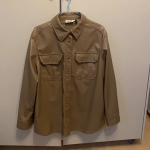 Skinnskjorta från Weekday - Superfin beige skinnskjorta från Weekday i strl S. Mycket bra skick 