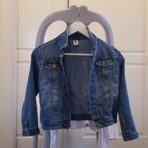 Jeansjacka - Detta är en cool jeansjacka med söta detalier ex hjärtknappar och nästan helt  oanvänd!  Kanske någo till din lilla syster, passar 7-8 åringar 