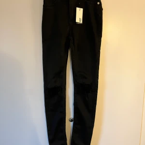 Svarta jeans - Svarta jeans från lager 157 med hål på knäna, oanvända Frakt tillkommer 