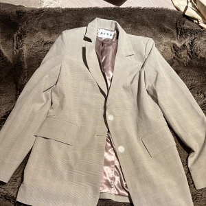 Kavaj - Kavaj/blazer i en fantastisk beige färg. Normal i längden och normal passform. Endast använd 1 gång.