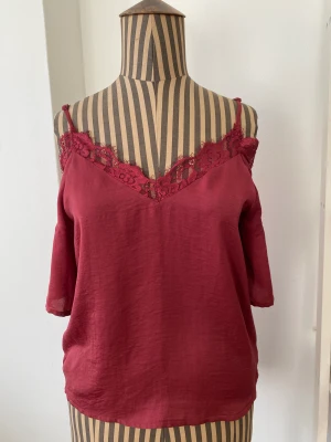 Vacker röd topp med spets - Härlig off-shoulder topp från Rut & Circle. Dämpad röd färg och fin spets. Troligen polyester. Nyskick!