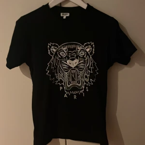 Kenzo T-shirt - Köpt på kenzo officiella hemsida för 4 år sen för ca 899kr. Säljes då den inte längre passar mig. Bra skick, inga tecken på användning. Pris kan diskuteras!!